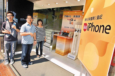 香港电讯商3香港、数码通及CSL昨日开始接受iPhone 4S网页及电话登记，有市民到门市查询。香港文汇报记者梁祖彝 摄